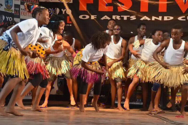 Young dancers in grass skirts performing on a stage.